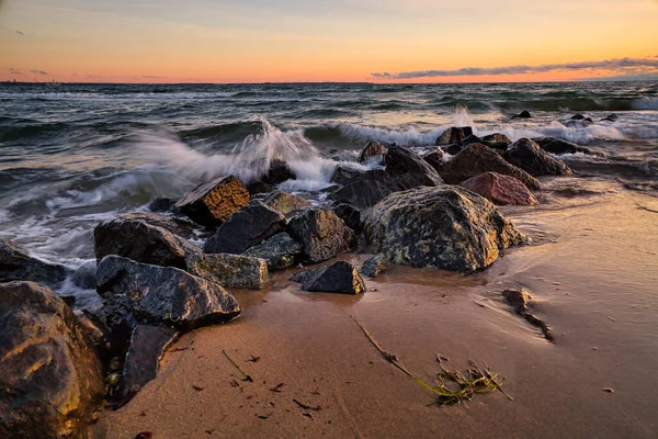 夕日のビーチで岩に衝突する波の美しいショット — ストック写真