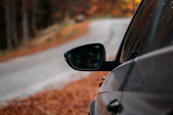 秋の日を背景に道路のある車のミラーの選択的フォーカスショット — ストック写真