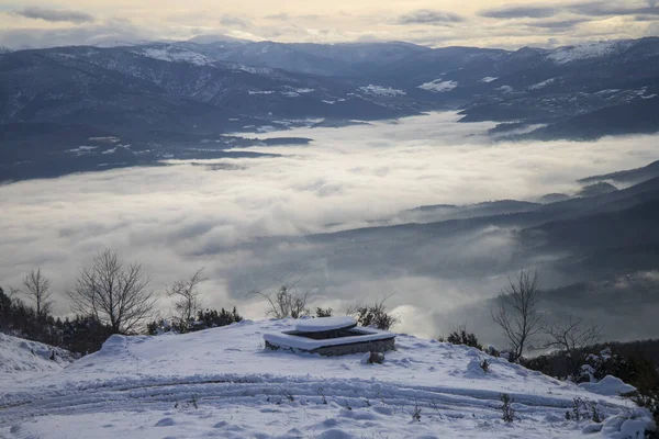 Ett Vinterlandskap Kulle Med Ett Snötäckt Picknickbord Molnig Himmel — Stockfoto