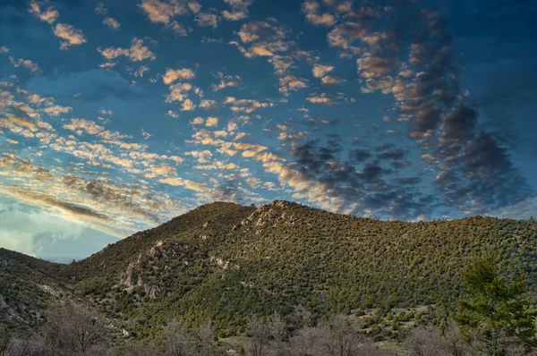 一片美丽的落日笼罩着青翠的小山 — 图库照片