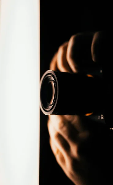 Вертикальний Темний Знімок Крупним Планом Фотографа Який Тримає Професійну Камеру — стокове фото