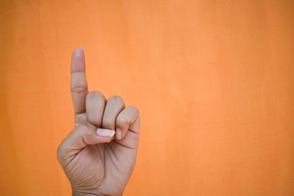 Ein Menschlicher Finger Zeigt Geste Vor Orangefarbenem Hintergrund — Stockfoto