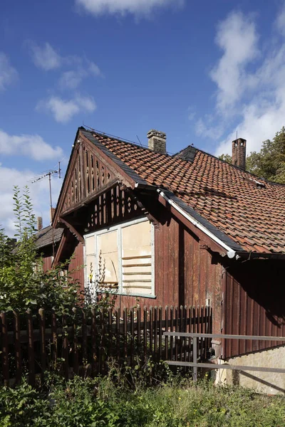 道路の近くにフェンスを持つ古い老朽化した木造の家の垂直方向のShof — ストック写真