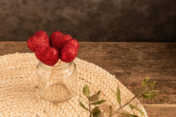 Low Angle Shot Jar Red Shiny Hearts Wooden Sticks Sisal — Stock Photo, Image