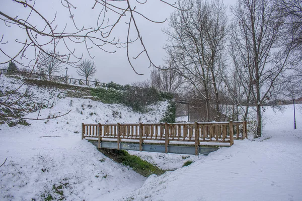 Malý Dřevěný Most Poli Pokrytém Sněhem Pod Zataženou Oblohou — Stock fotografie