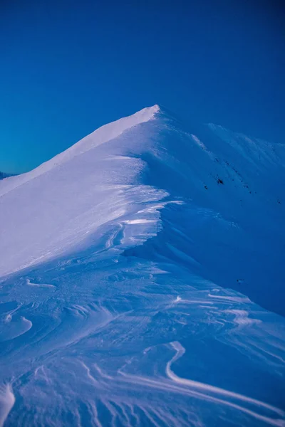 Eine Vertikale Aufnahme Von Schneebedeckten Bergen Unter Hellem Himmel — Stockfoto