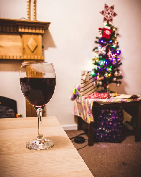 Masadaki Kırmızı Şarap Kadehinin Dikey Görüntüsü Arka Planda Süslü Bir — Stok fotoğraf