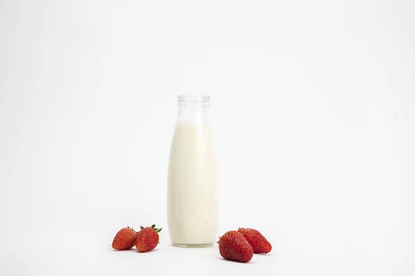 Бутылка Молока Окруженная Свежей Клубникой Белой Поверхности — стоковое фото