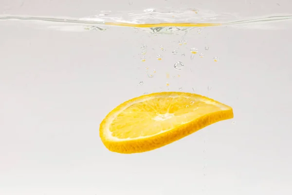 Una Rodaja Limón Flotando Agua Sobre Fondo Blanco — Foto de Stock