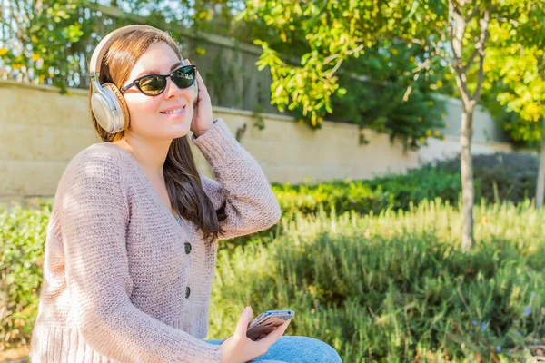Uma Mulher Sorridente Com Fones Ouvido Ouvindo Música Usando Smartphone — Fotografia de Stock