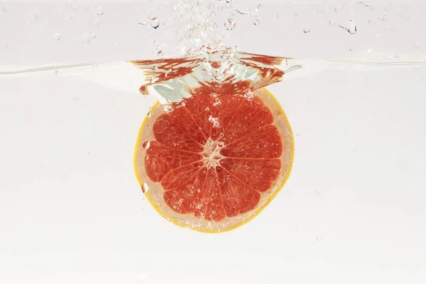 Egy Szelet Grapefruit Buborékol Vízben Fehér Alapon — Stock Fotó