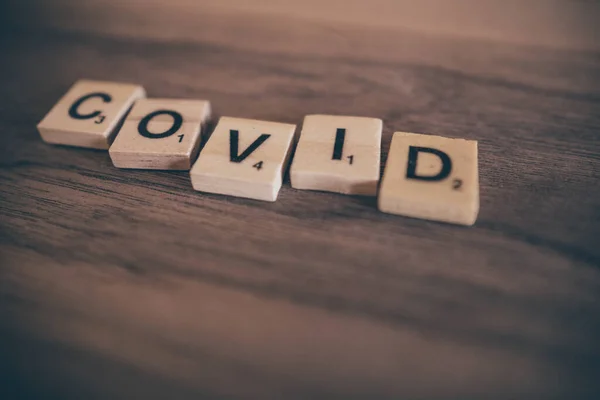 Litery Scrabble Drewnianym Tle Ortografii Słowo Covid — Zdjęcie stockowe