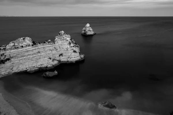 グレースケールでポルトガルのラゴスの海岸の岩場の崖の空中ショット — ストック写真