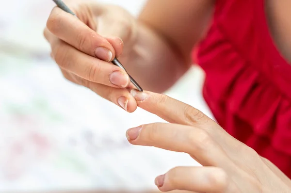 家庭での爪の治療のためのキューティクルプッシャーを使用して女性のクローズアップショット — ストック写真