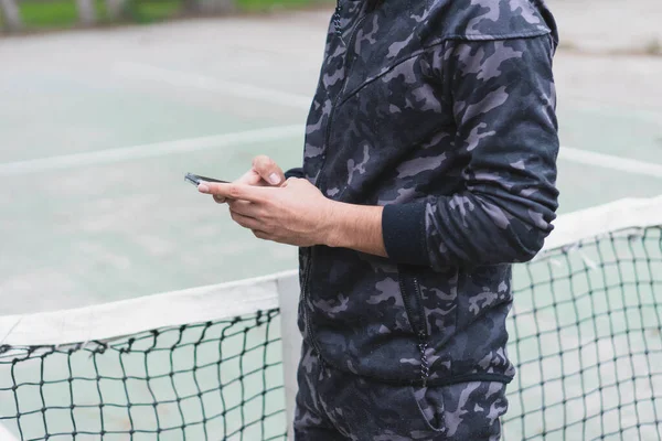 Ein Junger Sportler Schaut Auf Sein Handy Und Bereitet Sich — Stockfoto