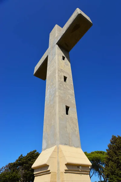 一个美丽的石头十字架的垂直的镜头在清晰的蓝色的S下 — 图库照片