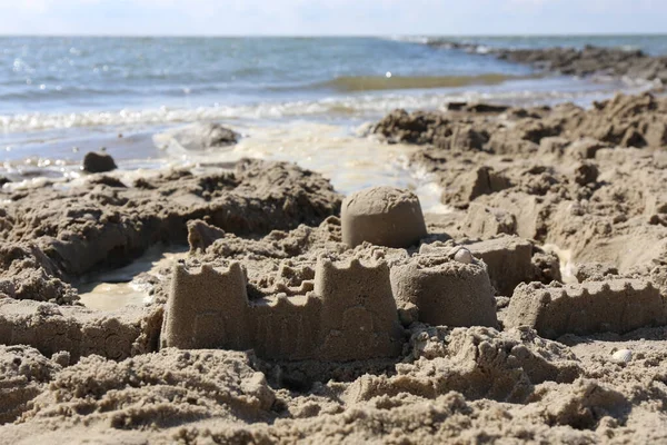 Eine Selektive Aufnahme Von Sandcasltes Der Nähe Des Welligen Meeres — Stockfoto