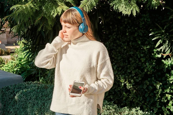 Genç Beyaz Bir Kadın Parkta Kulaklıkla Müzik Dinliyor — Stok fotoğraf