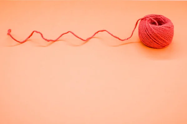 Closeup Shot Bright Red Woolen Yarn Peach Background — Stock Photo, Image