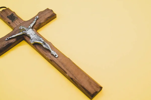 Tiro Close Uma Crucificação Madeira Cristo Cruz Sobre Fundo Amarelo — Fotografia de Stock