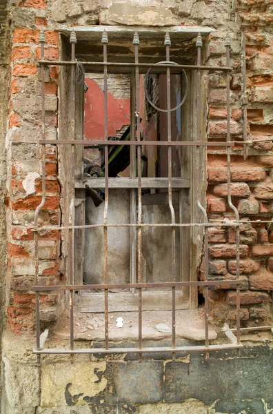 用木制窗户和生锈的金属门拍摄的一座被毁的旧建筑的垂直照片 — 图库照片
