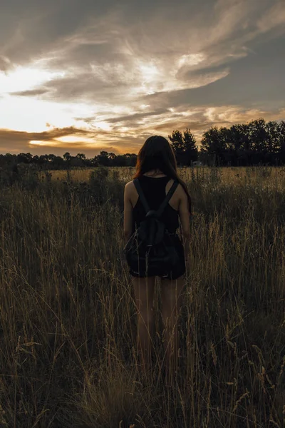 Вертикальный Вид Сзади Одинокой Девушки Черным Рюкзаком Поле Время Красивого — стоковое фото
