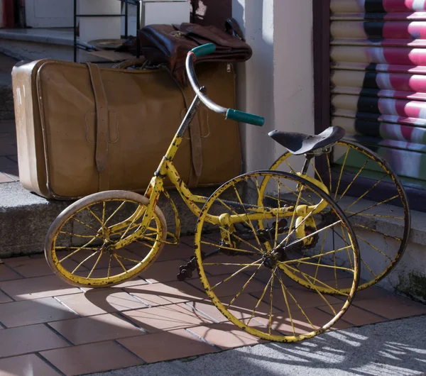 在街上的行李箱旁边拍到一辆旧的生锈的自行车的特写镜头 — 图库照片