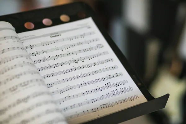 Een Close Van Muziek Notitiebladen Een Stand Met Een Wazige — Stockfoto