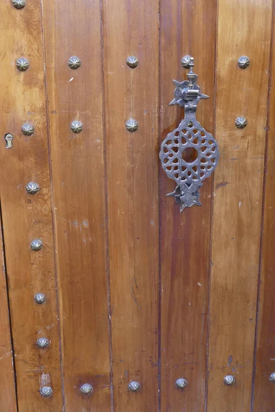 マラケシュの美しい装飾が施された金属製のドアハンドルを持つ木製のドアの閉鎖 — ストック写真