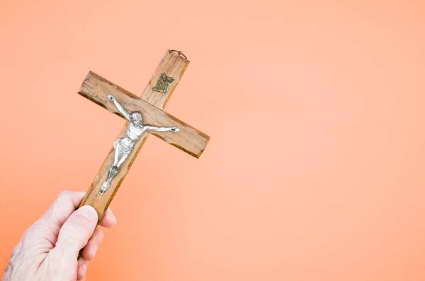 Closeup Shot Hand Holding Wooden Crucifixion Christ Cross Pastel Peach — Stock Photo, Image