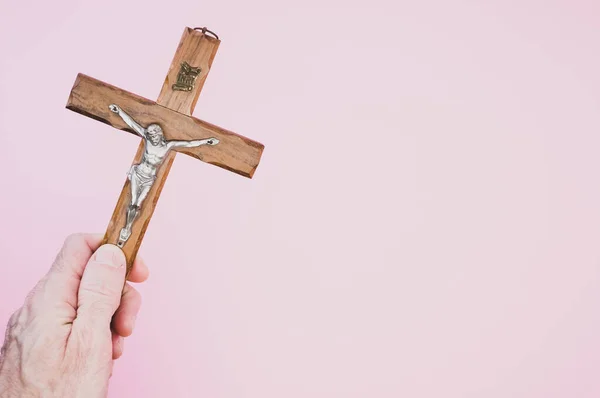 Closeup Shot Hand Holding Wooden Crucifixion Christ Cross Pink Background — Stock Photo, Image