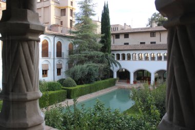 The Arab pool of the courtyard of the Alcazar minor with the cloister of the Monastery in front clipart