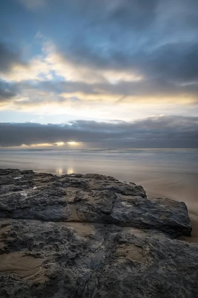 Eine Vertikale Aufnahme Eines Schlammigen Felsens Strand Mit Dem Meer — Stockfoto