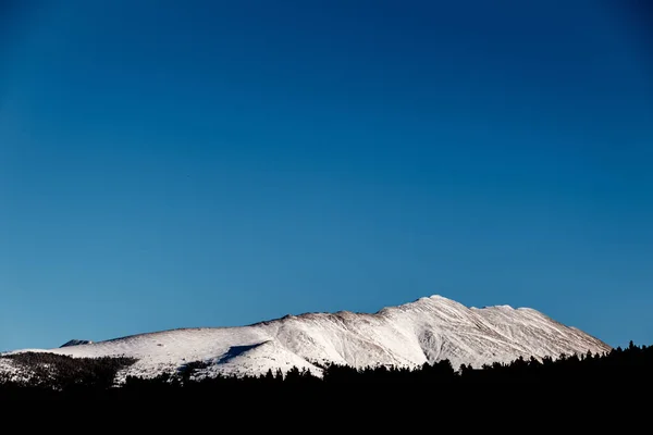 青空と太陽の下で雪に覆われた丘の風景 背景のために素晴らしい — ストック写真