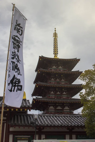 大阪の寺院の前に日本語で書かれた旗の縦のショット — ストック写真
