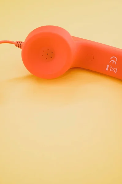 Вертикальный Снимок Оранжевого Телефона Бежевом Фоне — стоковое фото