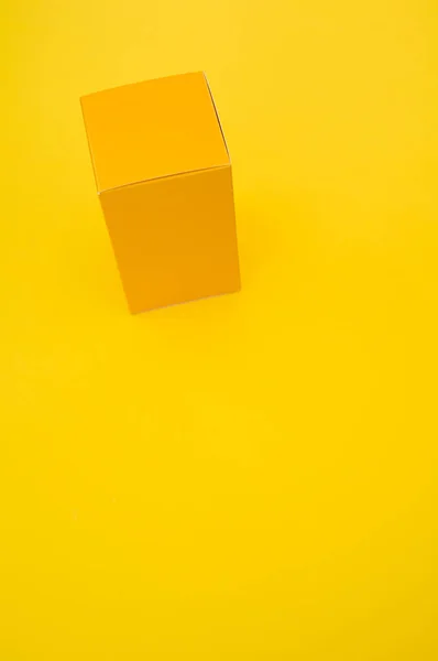 Ένας Κίτρινος Χάρτινος Κύβος Απομονωμένος Κίτρινο Φόντο — Φωτογραφία Αρχείου