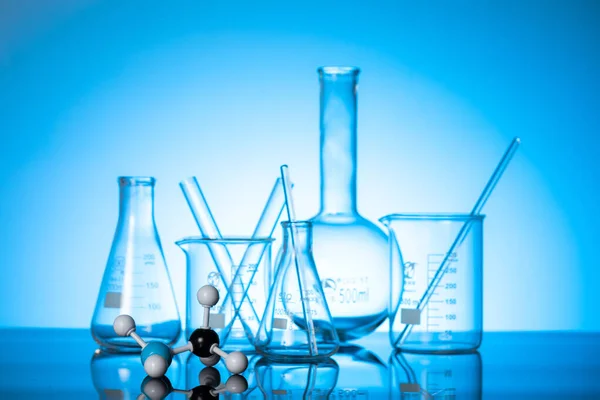 Eine Vielzahl Von Glasflaschen Und Laborgeräten Auf Blauem Hintergrund — Stockfoto