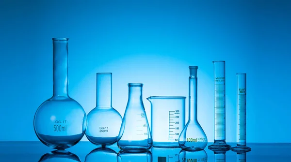 蓝色背景的各种玻璃瓶和实验室设备 — 图库照片