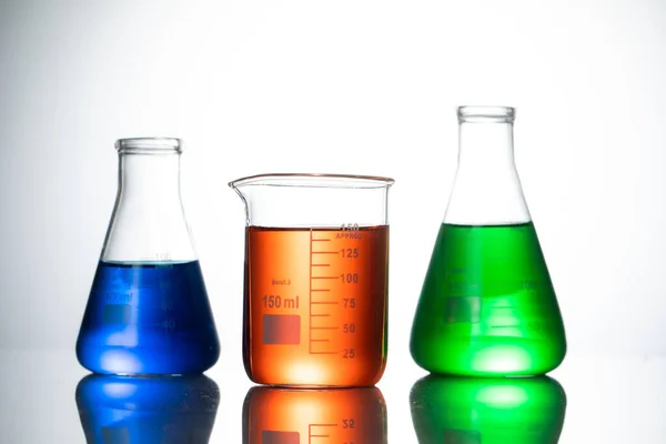 Różne Kolby Szklane Wyposażenie Laboratoryjne Kolorowymi Płynami Stole — Zdjęcie stockowe
