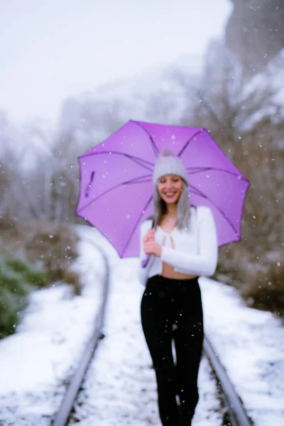 눈내리는 모자를 자주색 우산을 카프카스 소녀의 — 스톡 사진