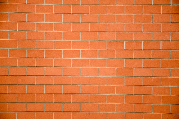 通りのパターンの背景にある建物のオレンジ色のレンガの壁のクローズアップビュー — ストック写真