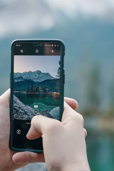 Выборочный Фокус Снимка Руки Человека Держащего Смартфон Фотографирующего Озеро Горы — стоковое фото