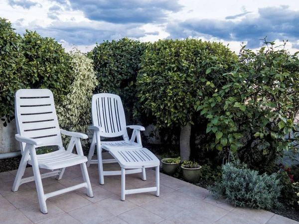一个庭院家具的特写镜头 两个舒适的塑料躺椅在美丽的花园里 — 图库照片