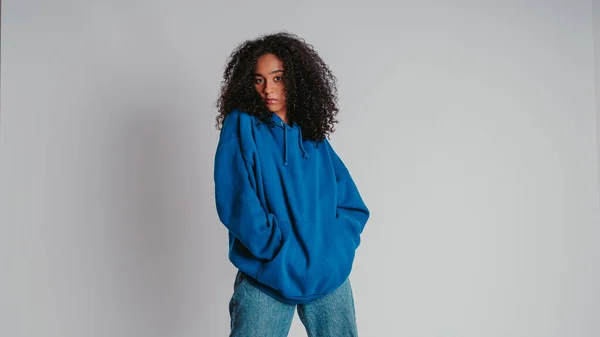 Een Mooi Krullend Meisje Poserend Een Blauwe Trui Jeans Een — Stockfoto