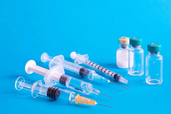 Detailní Záběr Různých Injekčních Jehel Vakcinačními Ampulkami Izolovanými Modrém Pozadí — Stock fotografie