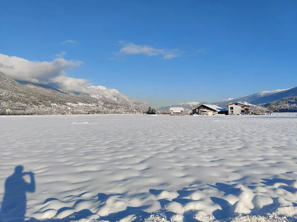 一个被雪覆盖的广阔的田野 后面是农村的房屋 — 图库照片