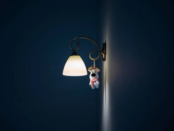 小さなおもちゃをぶら下げて壁に明るいランプの美しいショット — ストック写真