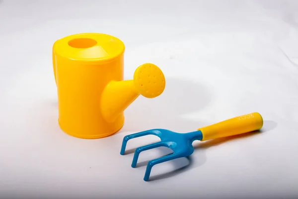 Tiro Close Uma Lata Rega Brinquedo Plástico Ancinho Uma Superfície — Fotografia de Stock