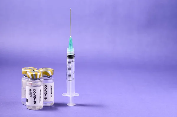Fechar Uma Agulha Seringa Com Ampolas Vacina Numa Superfície Roxa — Fotografia de Stock
